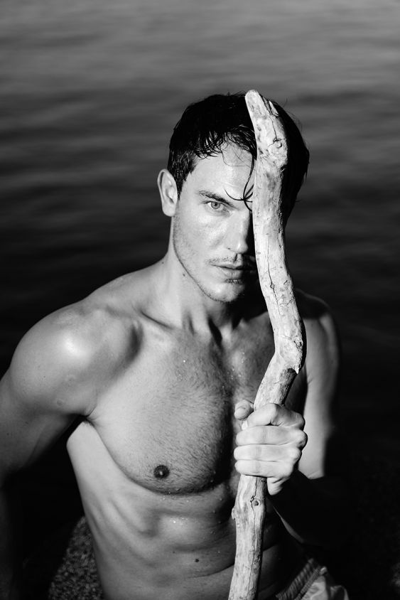 Portraits of male model by lake in black and white 